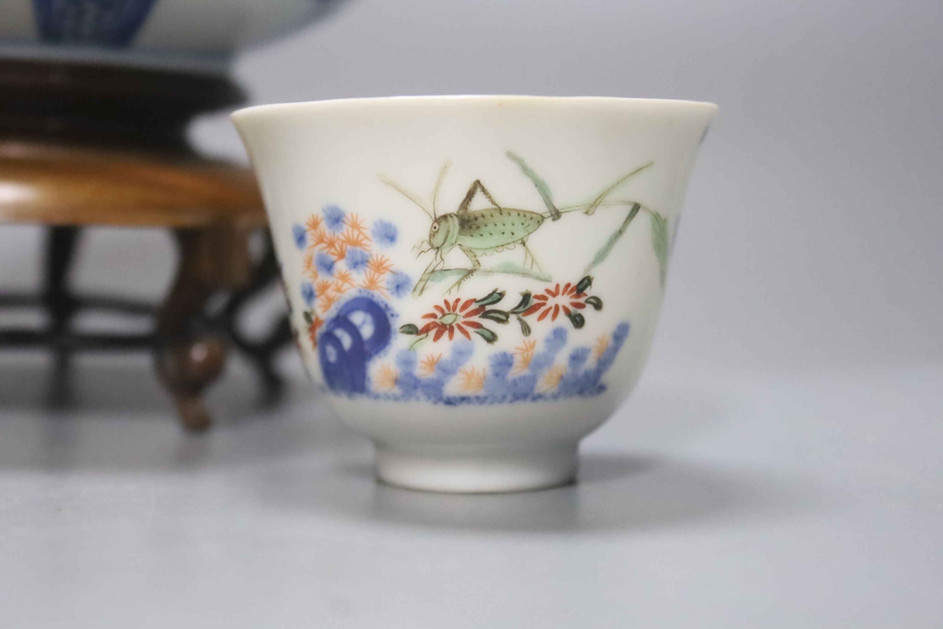 A pair of Chinese blue and white jars and covers, 6.5cm, on wood stands, a Chinese blue and white bowl and two small enamelled wine cups